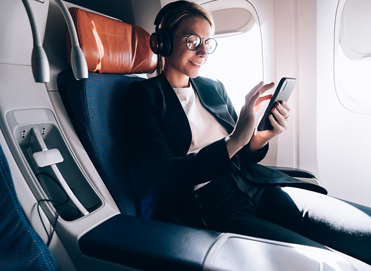 A corporate traveller using her phone aboard an aircraft
